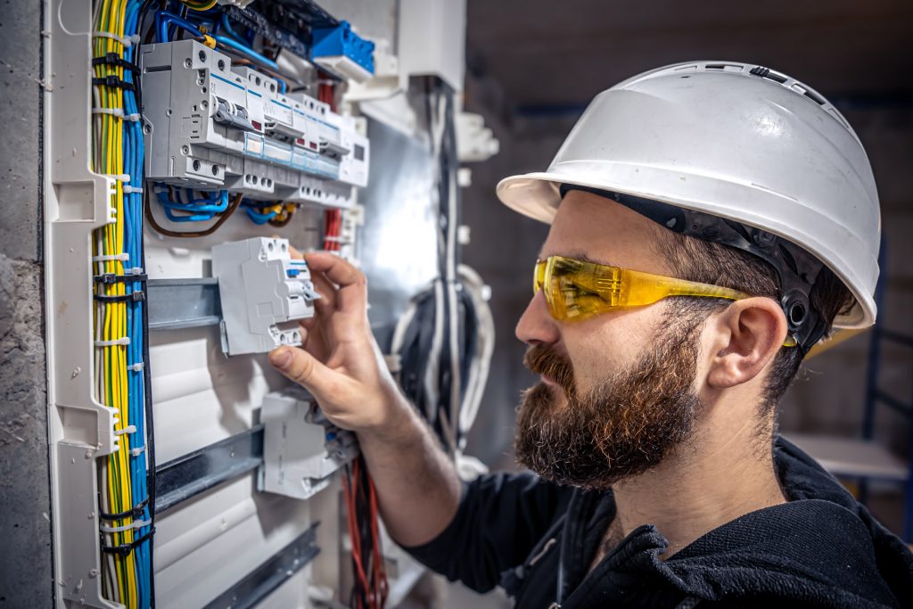 Pogotowie Elektryczne Warszawa Elektryk podczas pracy przy instalacji elektrycznej